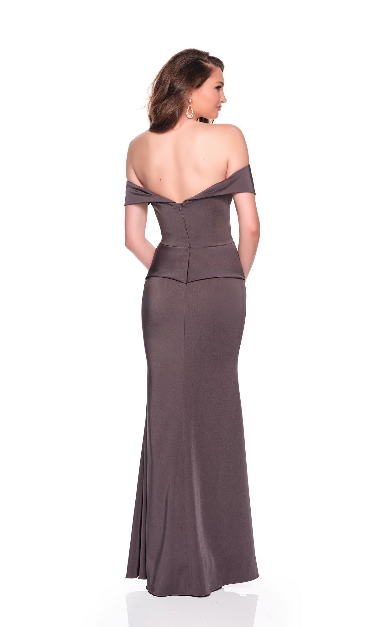 A woman models the Dave and Johnny 12571 long prom dress, featuring an off-the-shoulder, fitted grey silhouette. She faces away, showcasing the elegant back of the gown and her loose, wavy hair.